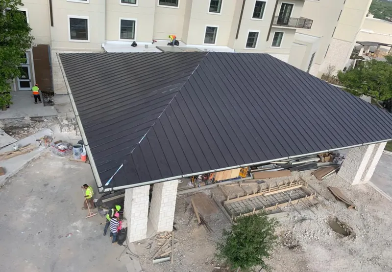 Metal roofing installation team working on a commercial building in Vestal